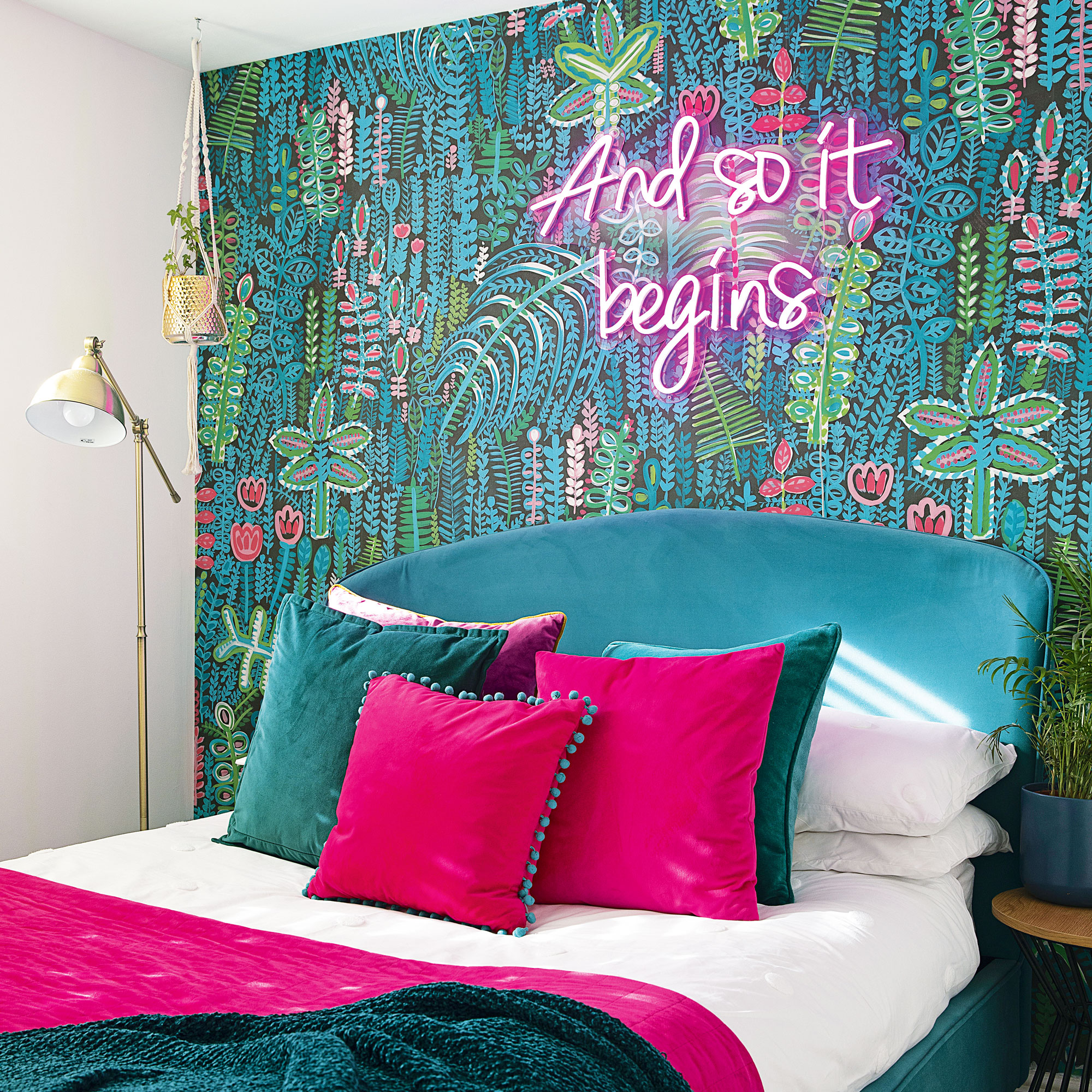 pink and green themed bedroom with botanical wallpaper, neon light and gold floor lamp