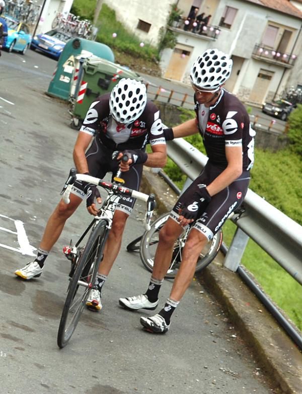 A quick wheelchange from a nearby teammate helps Carlos Sastre (Cervelo Test Team) get back underway after a puncture.