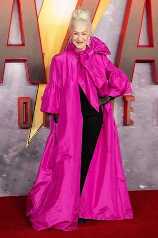 Helen Mirren wearing a pink caped dress with an oversized bow