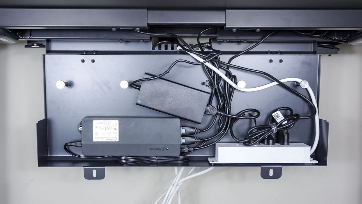 A close-up shot showing the Autonomous SmartDesk 5's built-in cable management compartment