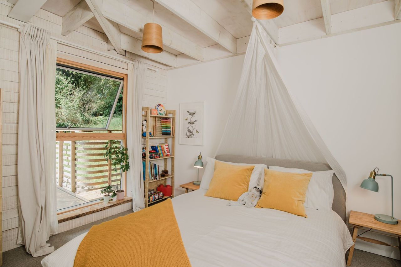 The bedroom has a half-opening window and curtains to cover the bed