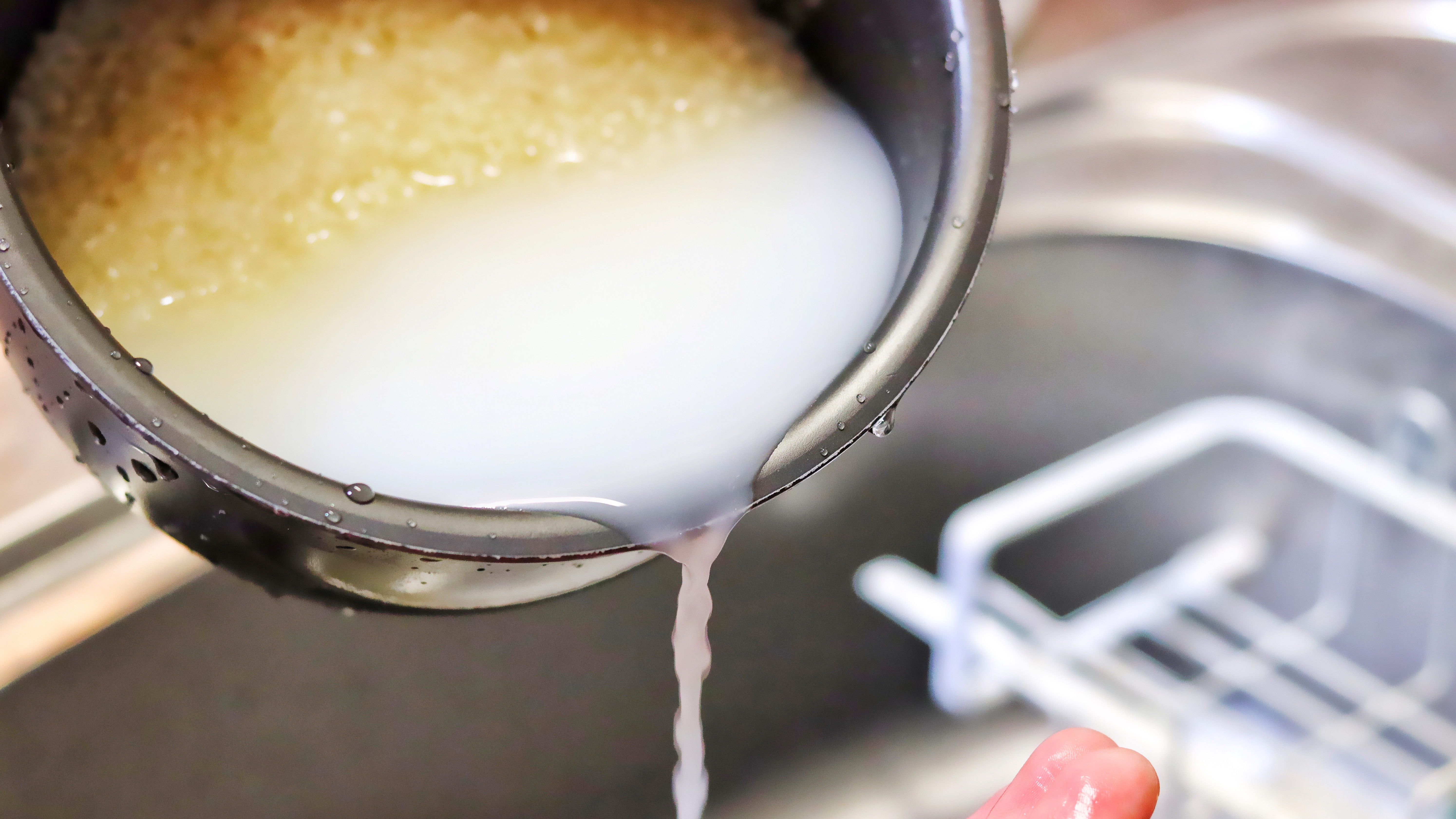 Draining rice water from a pot