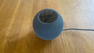 Apple HomePod Mini on a wooden surface