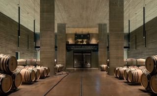 The primary barrel room, lined with board-formed concrete and with a glassed tasting area above, is set into the earth, for stable temperature and humidity