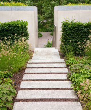 An example of sloping garden ideas showing a garden on a slope with steps leading down