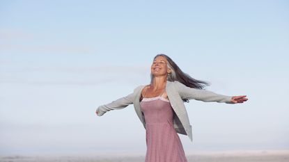 Woman walking with her arms stretched out as if flying