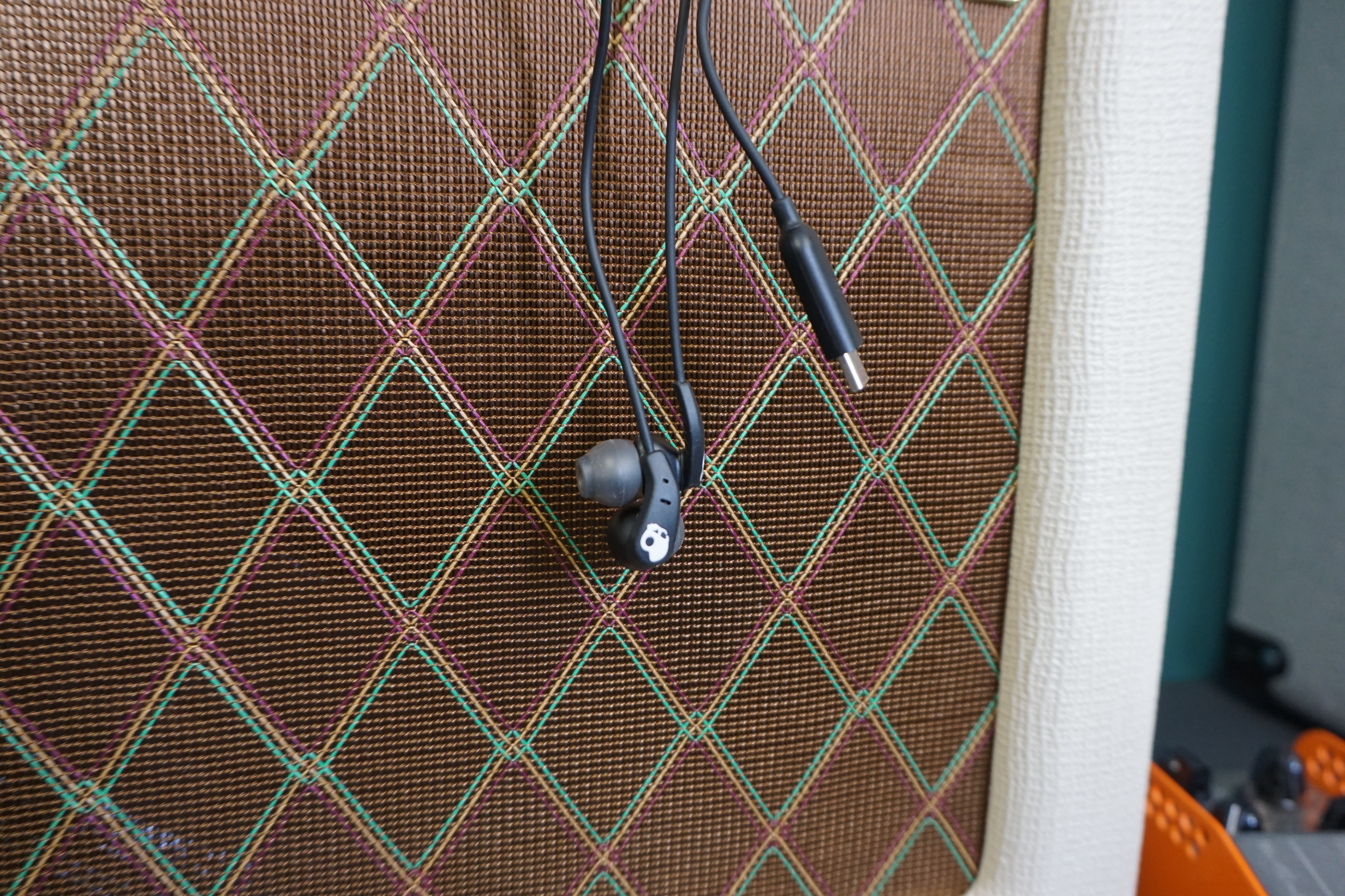 Skullcandy Set USB-C earbuds against guitar amp