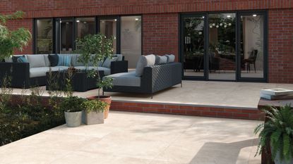 large L shaped patio with seating area and step leading down to a lower level