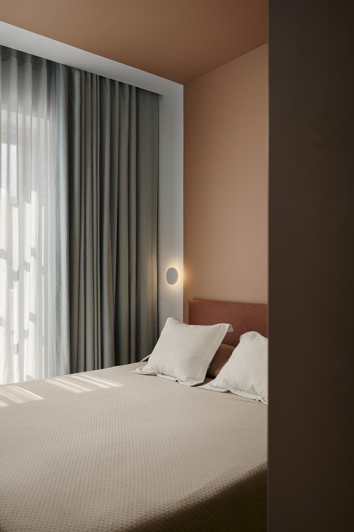 A bedroom with blackout curtains and sheer lining