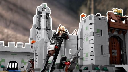 Lego Helm's Deep with minifigures fighting on the battlements, with a blurred shot of the valley behind