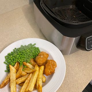 Image of air fryer with plate of scampi and chips