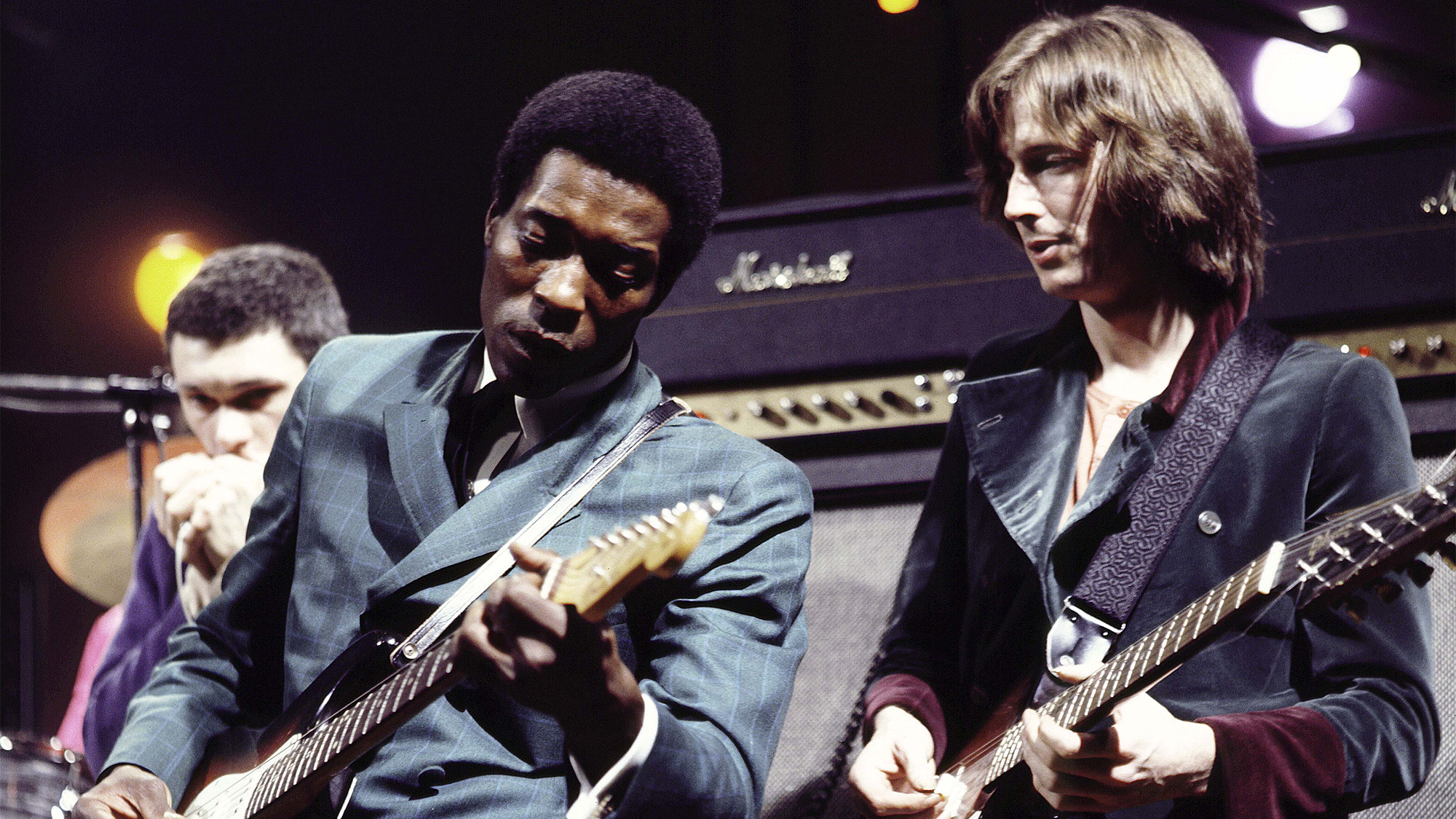 Buddy Guy on stage with English guitarist Eric Clapton at the Supershow session at a disused factory in Staines, England on 26th March 1969. Eric Clapton plays a 1964 Gibson Firebird guitar.
