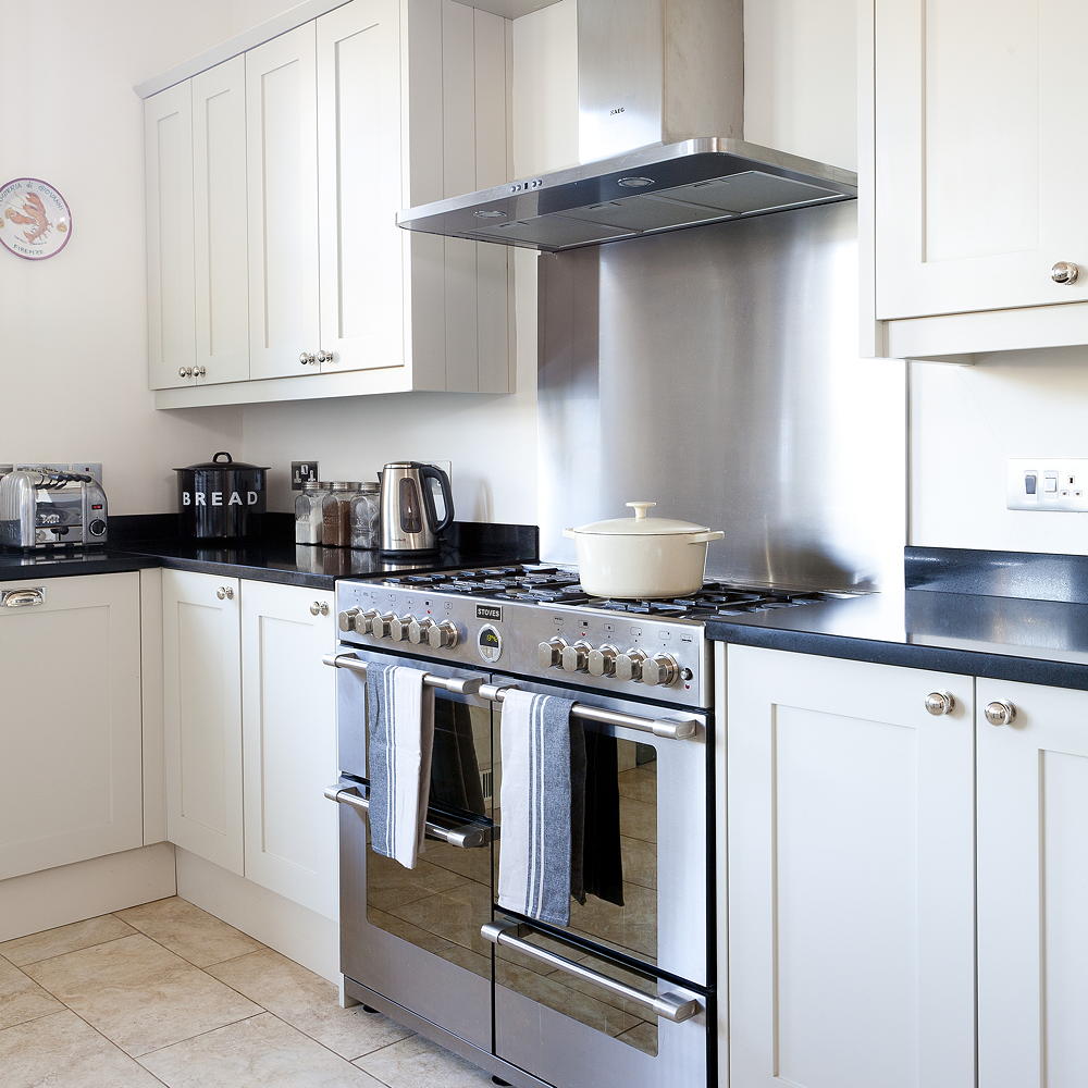 kitchen with white wall white cabinets and chimney