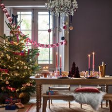 Dining room with decorated tablescape and decorated Christmas tree and presents
