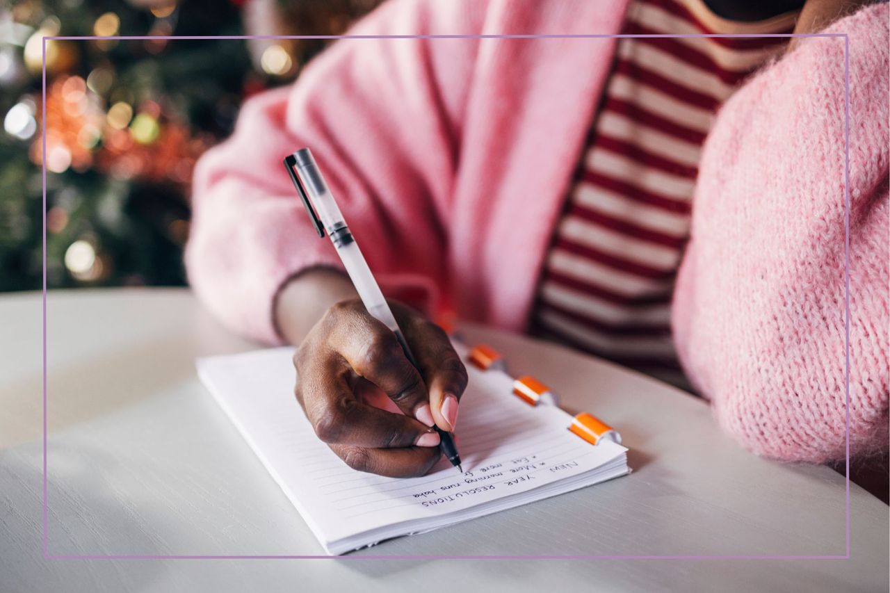 Person in striped top writing down in a notepad