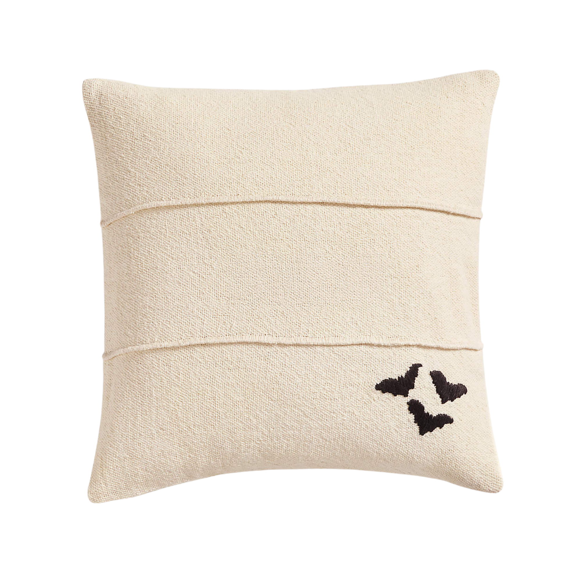 a beige pillow with three bats in the bottom corner