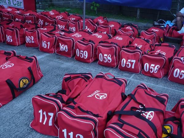Racers transport their belongings from stage to stage in race-issued red bags