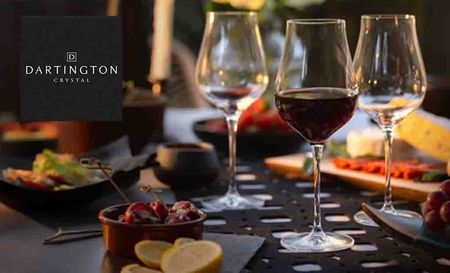 Dartington Crystal logo top left with a picture of three glasses of wine on a dinner table
