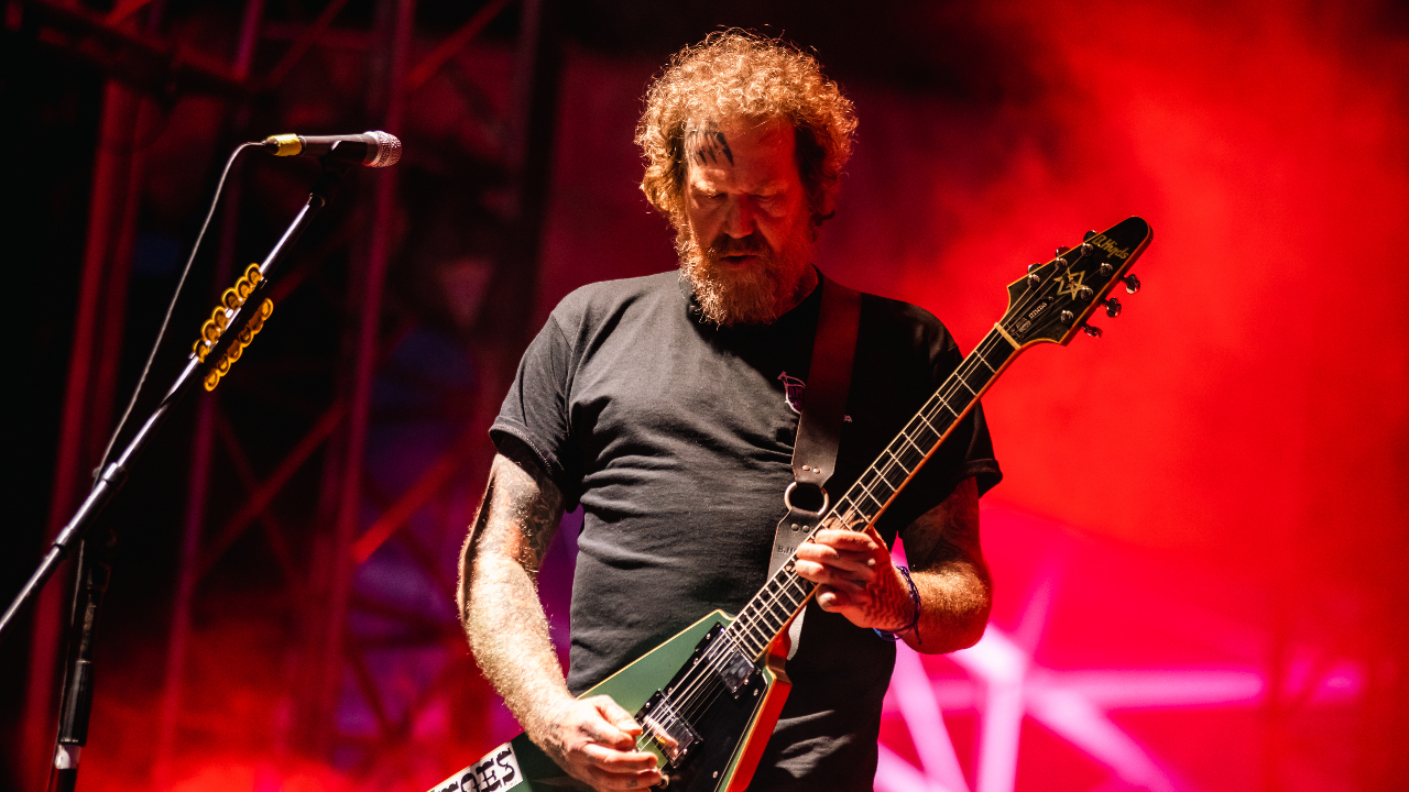 Brent Hinds looking down at his guitar on stage