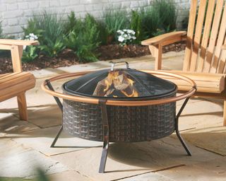 covered fire pit on patio with garden chairs