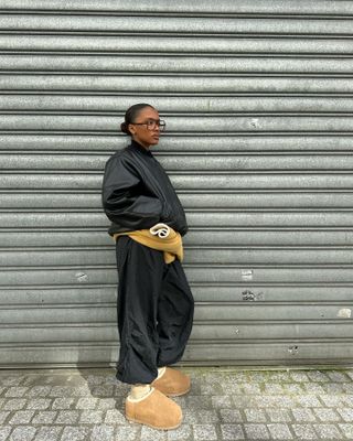 Fashion influencer  @mv.tiangue wearing a chic winter outfit in Paris featuring controversial Ugg footwear.