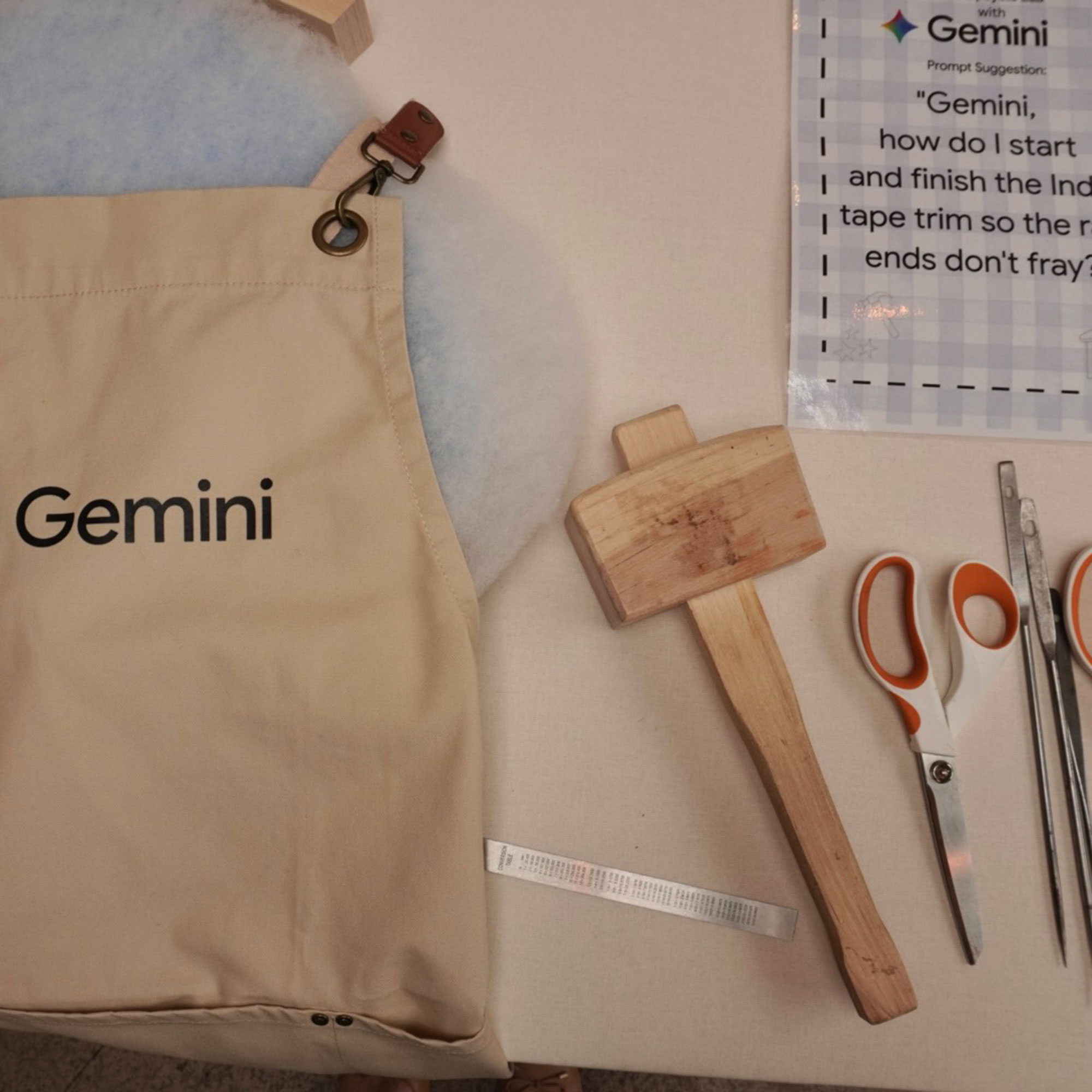 Flat lay of Google Gemini apron and upholstery tools including scissors
