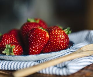 Strawberries on a table with a wooden spoon