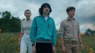 Eleven, Mike y Will miran a lo lejos desde una colina en Stranger Things temporada 4