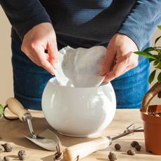 adding coffee filter to plant pot