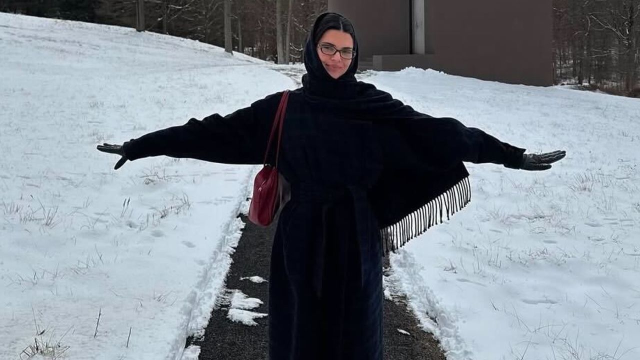 Kendall Jenner in the snow wearing a scarf coat