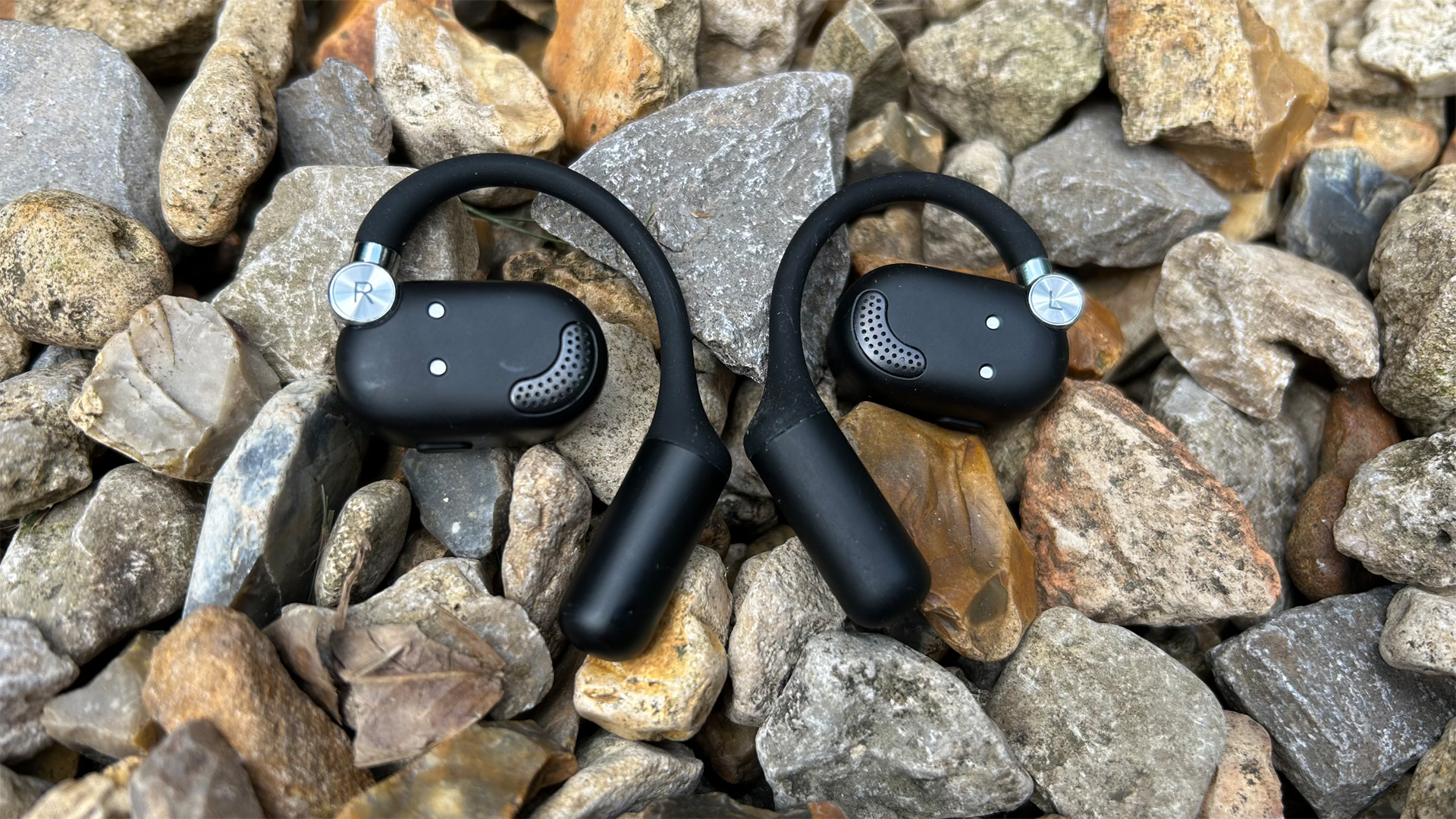 The rear of the OpenRock X headphones on gravel
