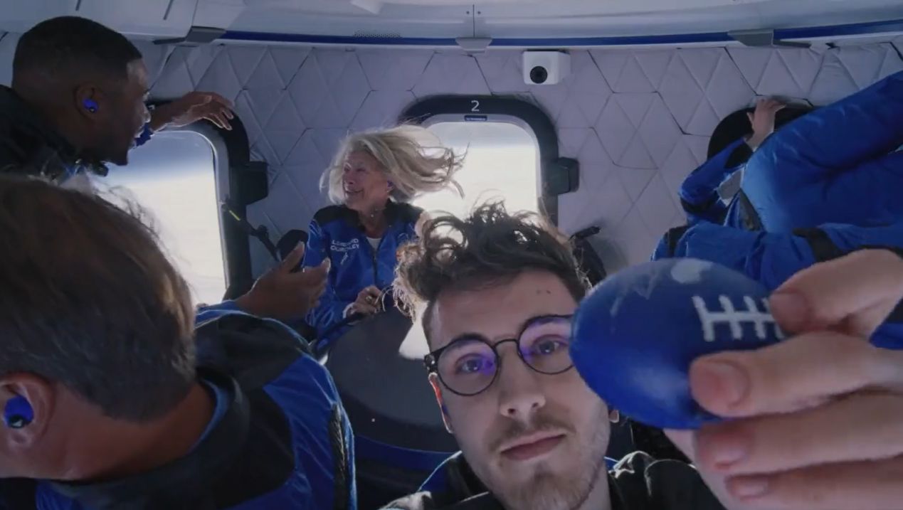 Blue Origin New Shepard NS-19 passenger Cameron Bess holds up a toy football while floating in weightlessness during their suborbital spaceflight on Dec. 11, 2021.
