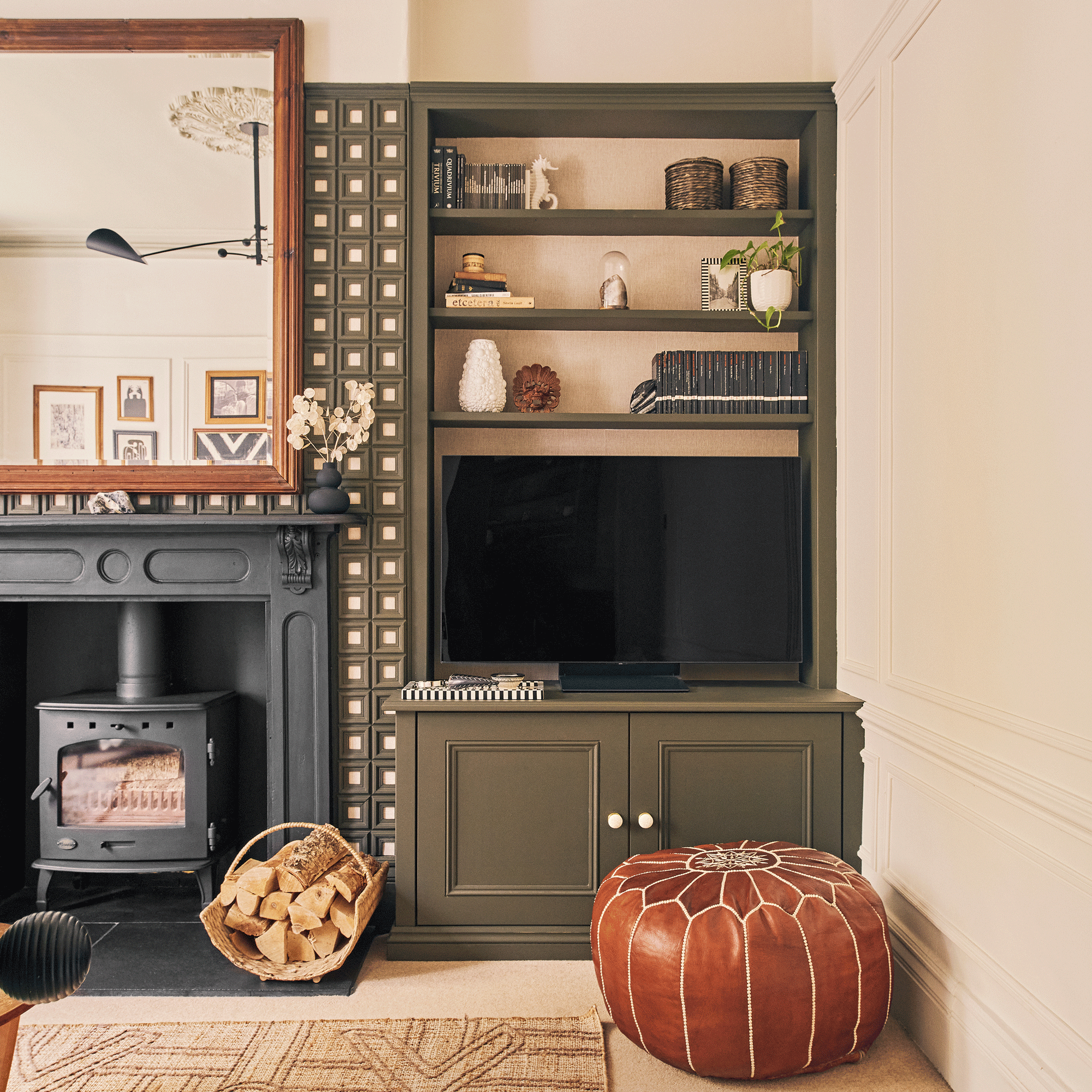 a living room with alcove shelving, fireplace with mantelpiece and a TV and large mirror
