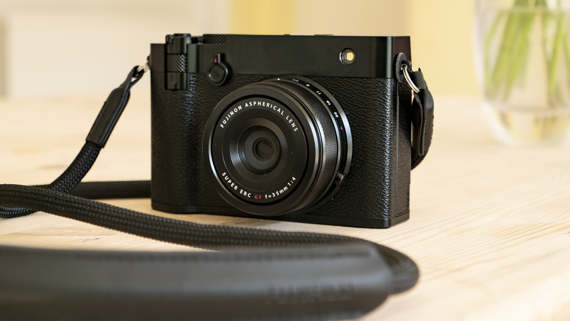 All-black Fujifilm GFX100RF rangefinder-style camera on a wooden table