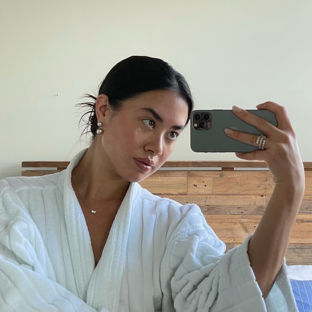 Woman taking a mirror selfie in a robe