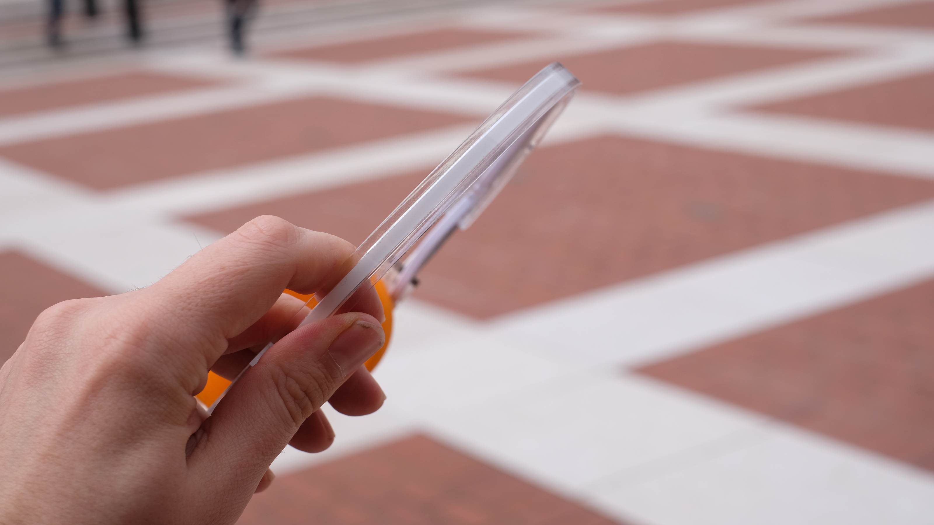 A photograph of the FiiO EH11 over-ear headphones with a transparent frame and orange foam earpads.