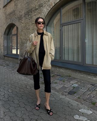 Fashion influencer Annabel Rosendahl on the street in Copenhagen wearing a chic fall outfit styled with black capri pants.