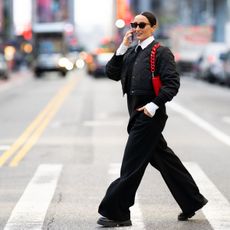 Well-dressed businesswoman walking on the street of Manhattan, New York and talking on the phone while heading to work during one autumn day.