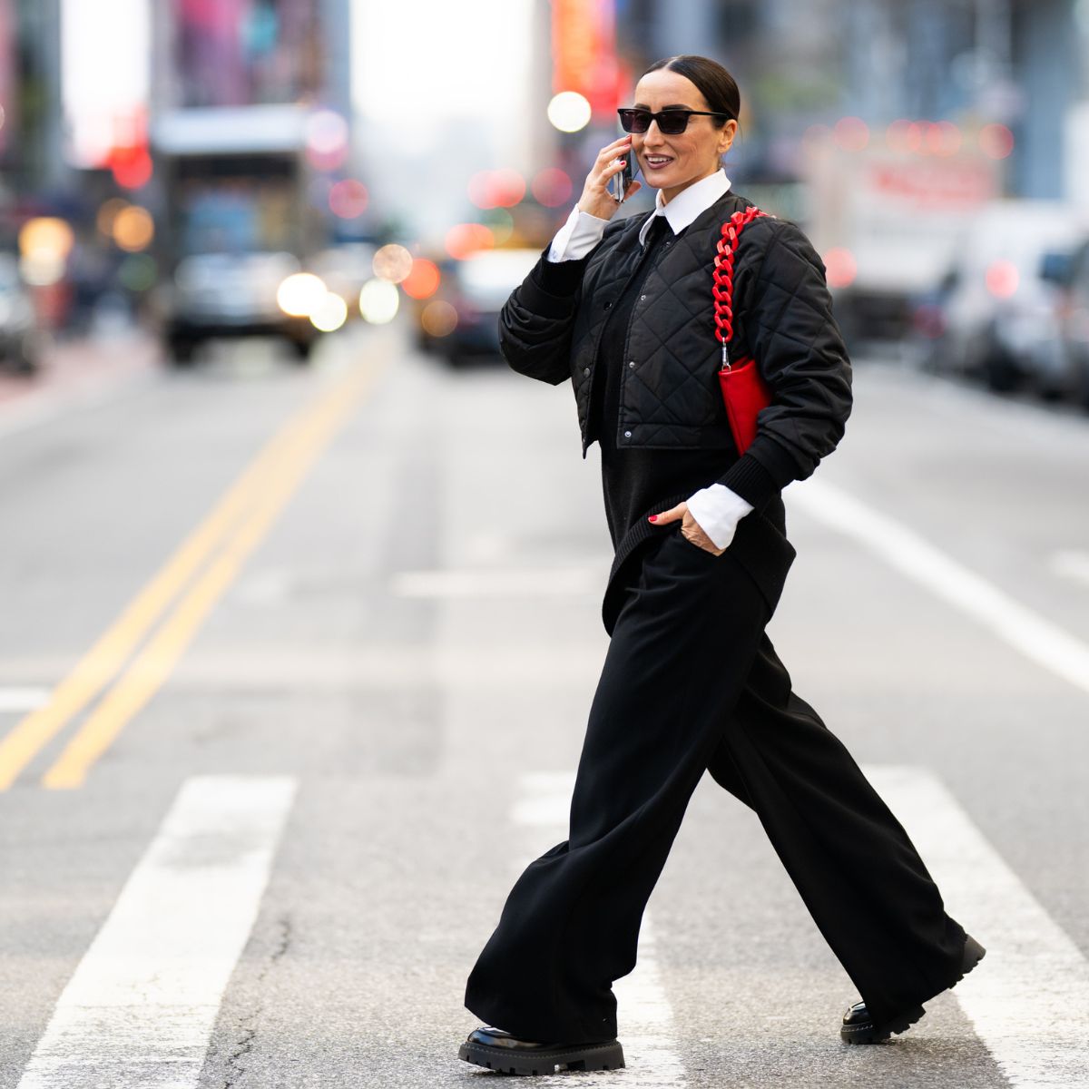 Well-dressed businesswoman walking on the street of Manhattan, New York and talking on the phone while heading to work during one autumn day.