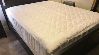 A bed covered by the Nolah Bamboo Mattress Pad