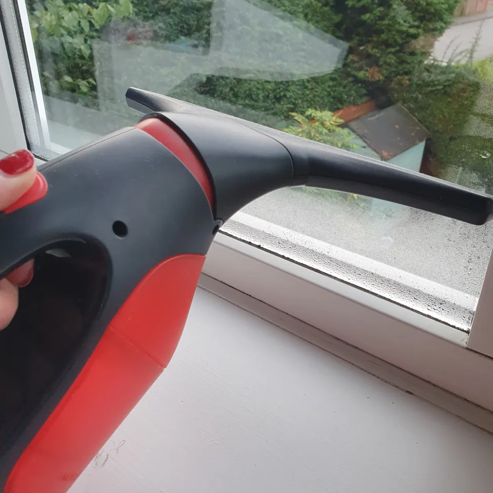 Michelle holding the Vileda Windomatic Power Window Vac, one of the best window vacs, on her condensation window