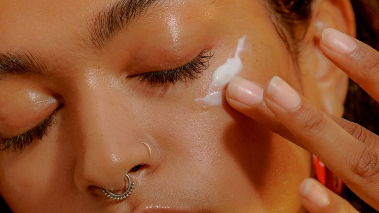 Woman applying eye cream to her undereye