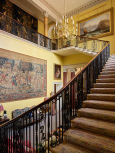 Fig 2: The cantilevered main stair, with its exquisite Regency iron balustrade, rises to the bedroom corridor. Note the two colours of scagliola column at ground and first floor. Spetchley Park, Worcestershire. ©Paul Highnam for Country Life