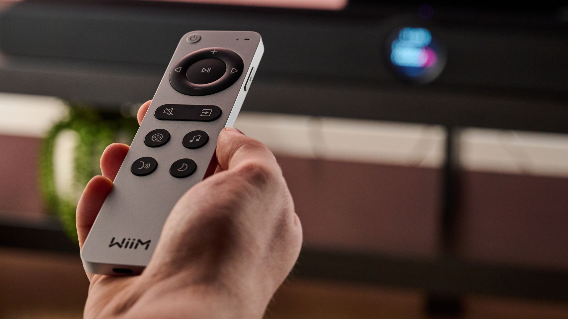 Man holding the WiiM Bar remote