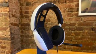 Sony Inzone H3 gaming headset on a stand against a brick wall