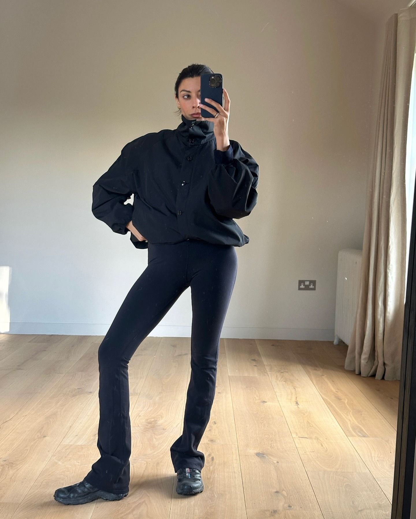 Influencer wearing leggings with a windbreaker and black sneakers