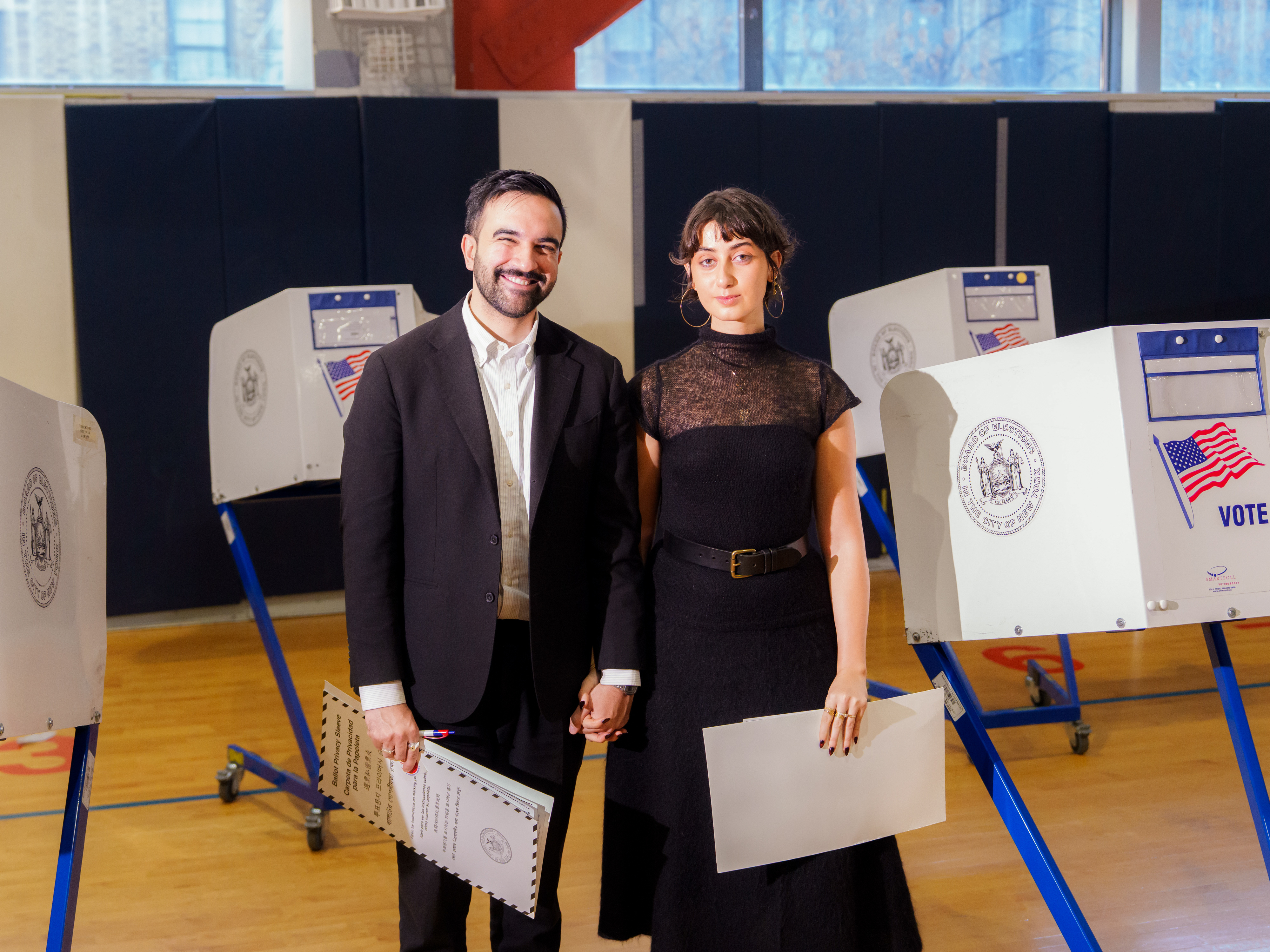Rama Duwaji wearing a high neck lace blouse with a black skirt and a belt
