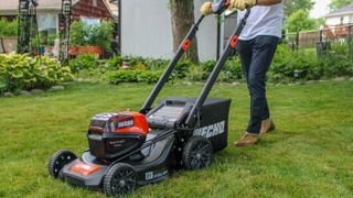 A person using the ECHO DLM-2100 SP self-propelled lawn mower