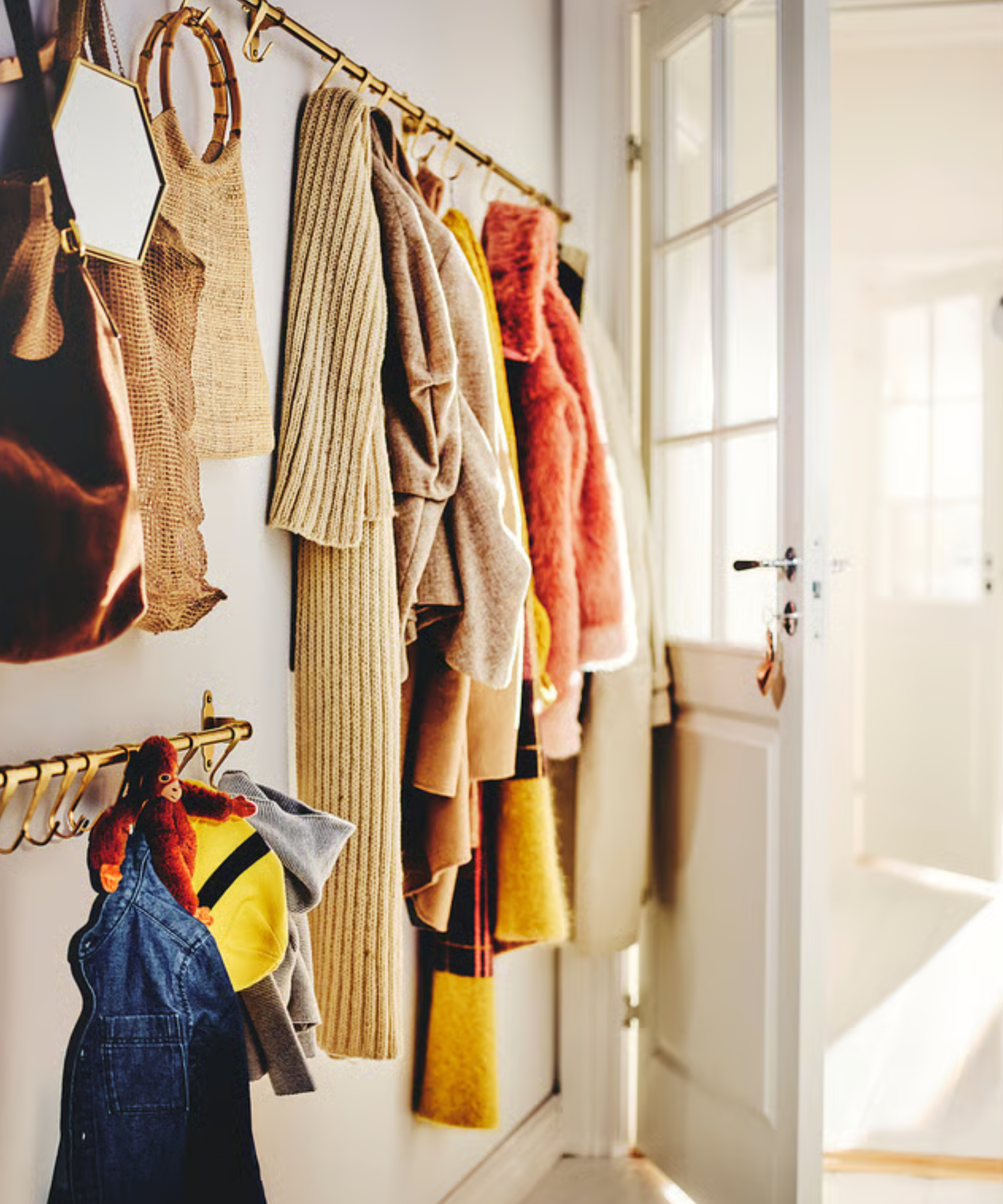 an entryway with coats hung from a storage rail