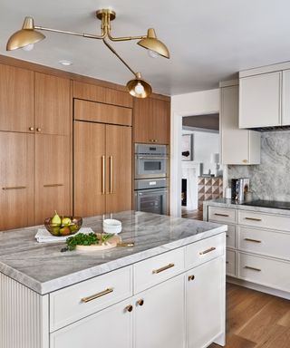 modern kitchen with light gray cabinets, marble countertops and wooden built-in storage